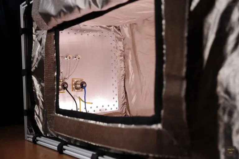 Shielded enclosure made from conductive fabric, showing the base plate with installed power-supply line filters and partially visible N- and BNC-type connectors