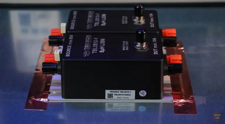 Two TekBox TBL0510-1 5 µH LISNs securely bonded to the reference ground plane using copper tape strips; the factory-installed 1 µF capacitor on the ground-return LISN (right) has not yet been removed